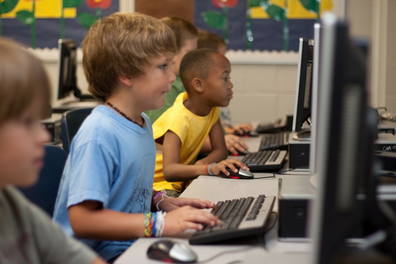 Kinder in der Schule vor dem Computer am Programmieren